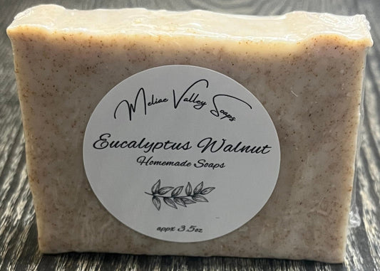 Bar of soap with a label on a wooden surface.