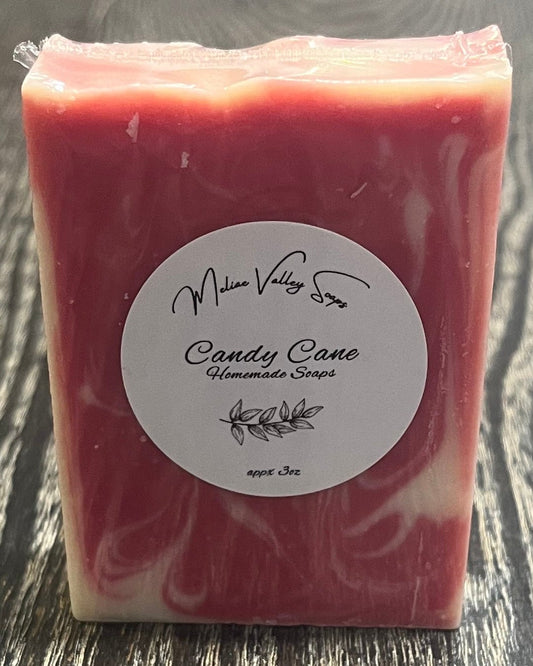 Red bar of soap with a label on a wooden surface.