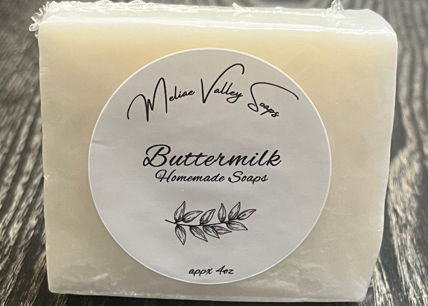 A white bar of soap with a label on a wooden surface.