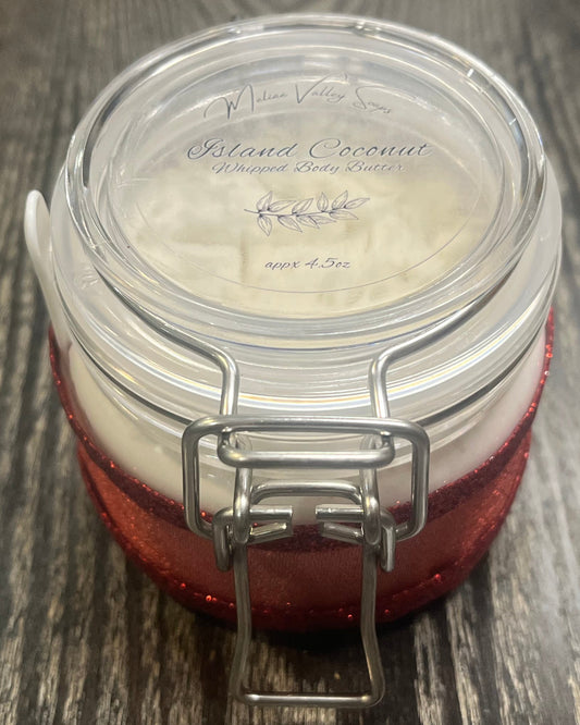 Clear round jar with a sticker on top. You see through to the jar to white body butter.