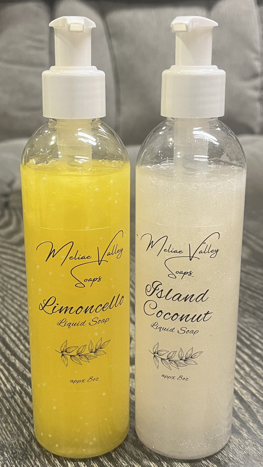 A set of pump bottles with different colored liquids, white and yellow, next to each other on a wooden surface.