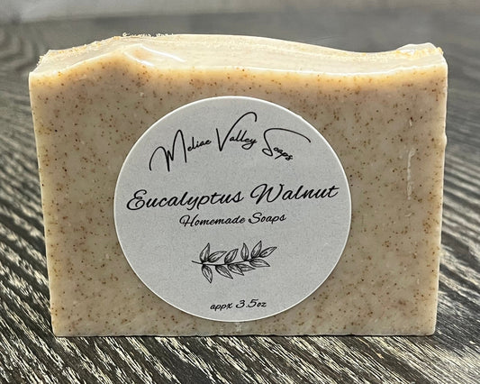Bar of soap with a label on a wooden surface.