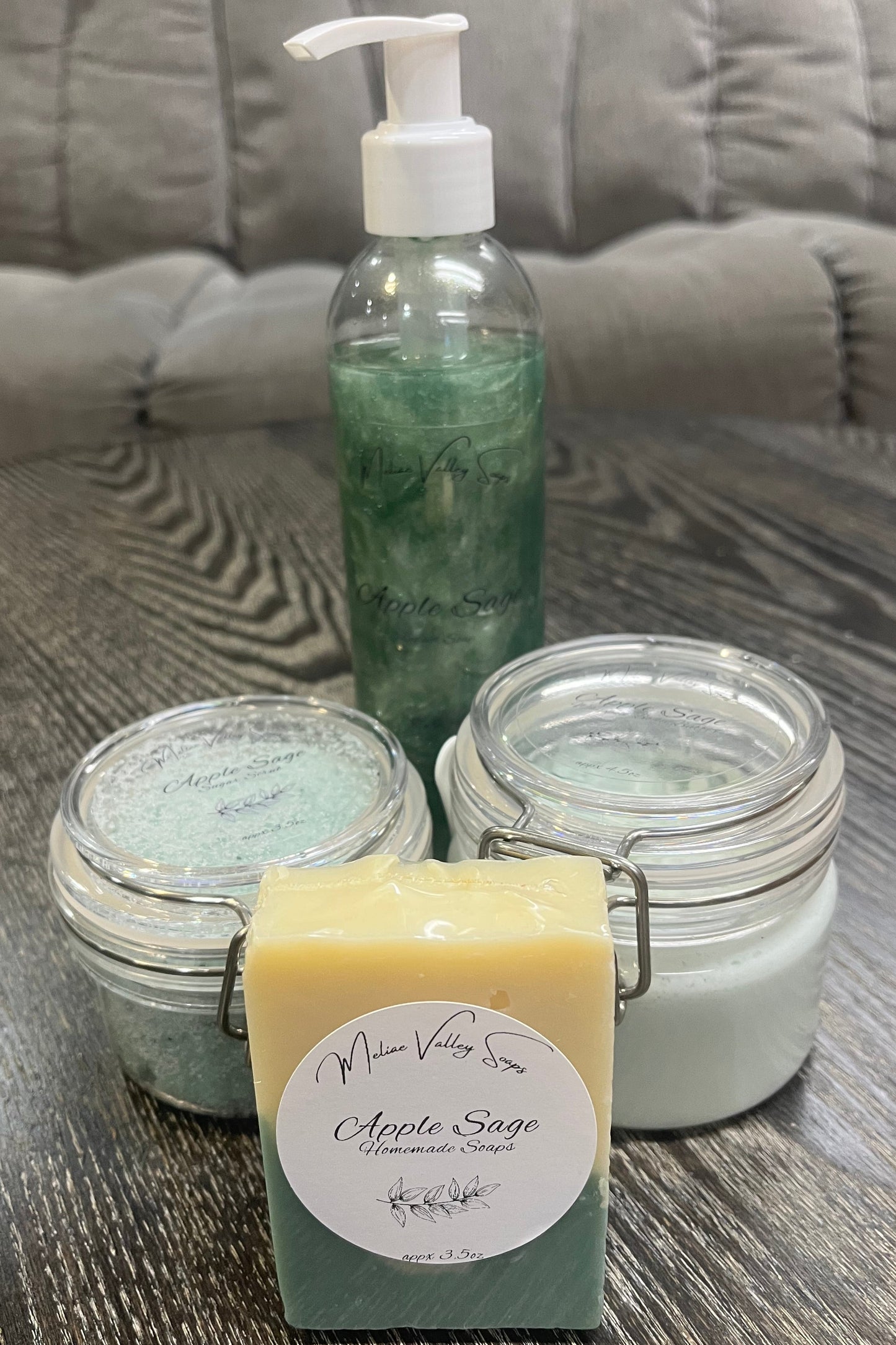 A set of beauty products, including a bottle, jars, and a bar on a textured surface.