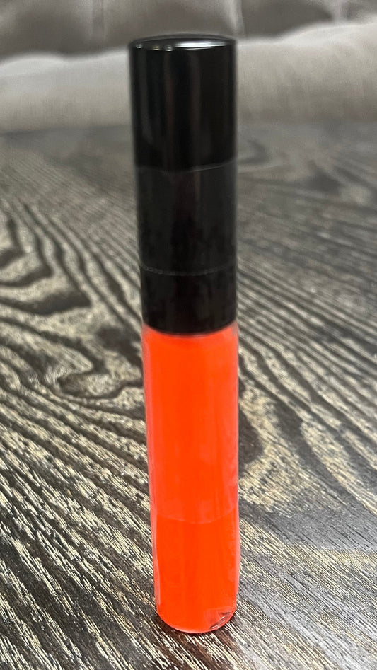 A bright orange tube of lip gloss.