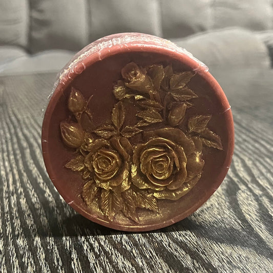 A red bar of soap with gold mica painting on the designs.