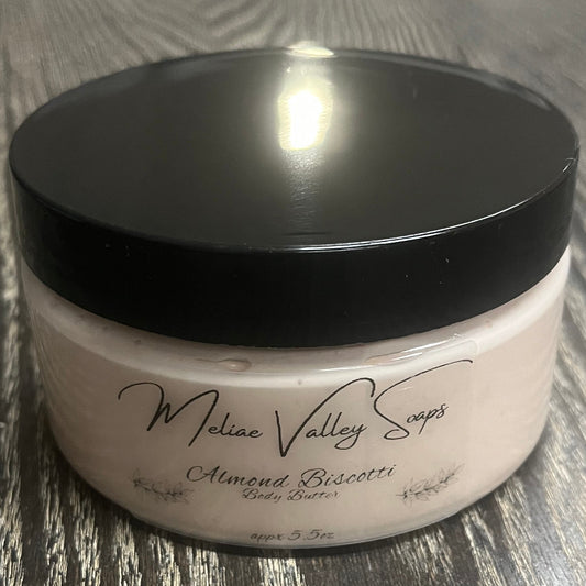 Jar of light brown whipped body butter with a black lid and a clear label on the front.