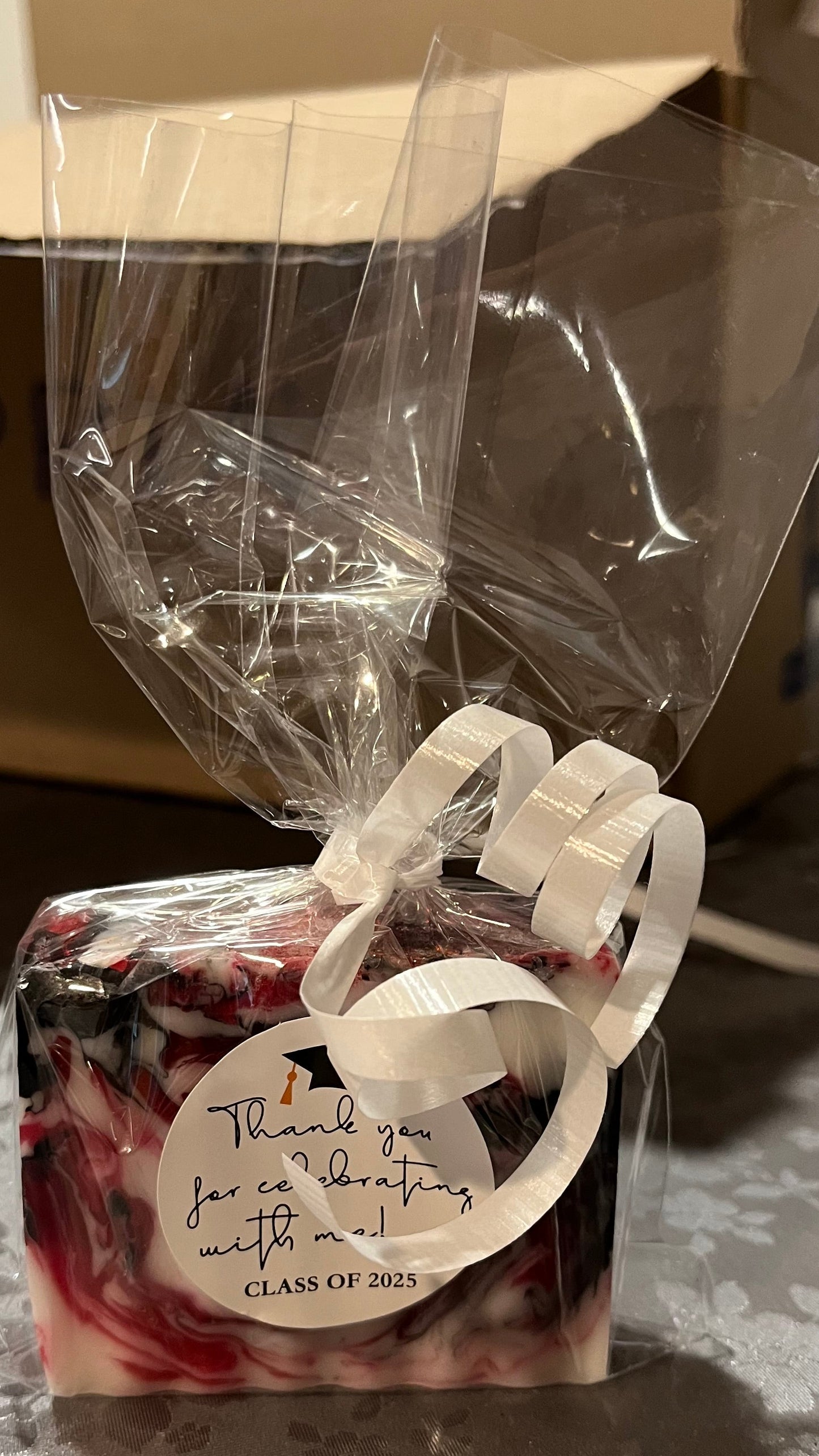 Small gift bag with a ribbon and label containing a bar of soap.