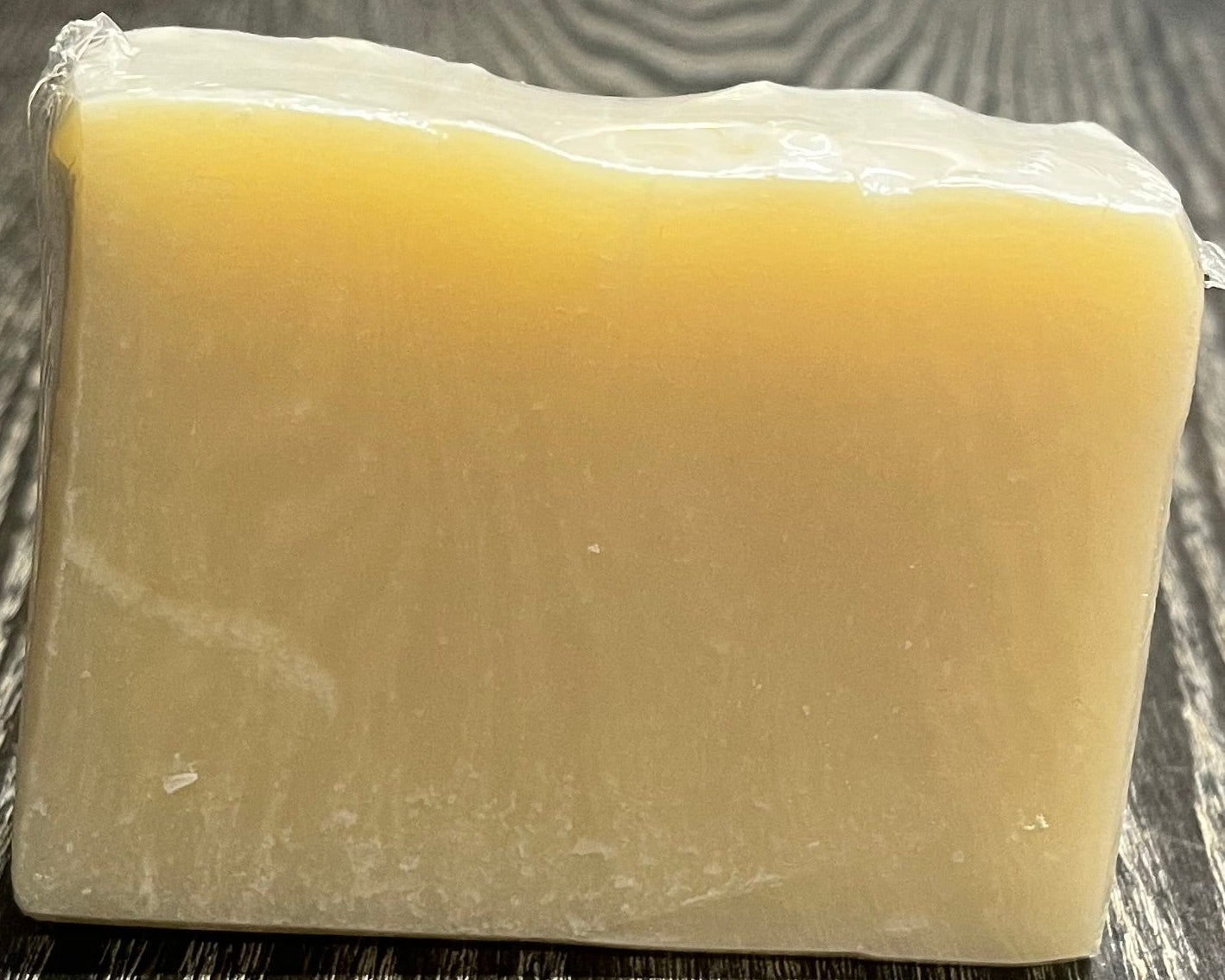 Block of soap on a wooden surface.