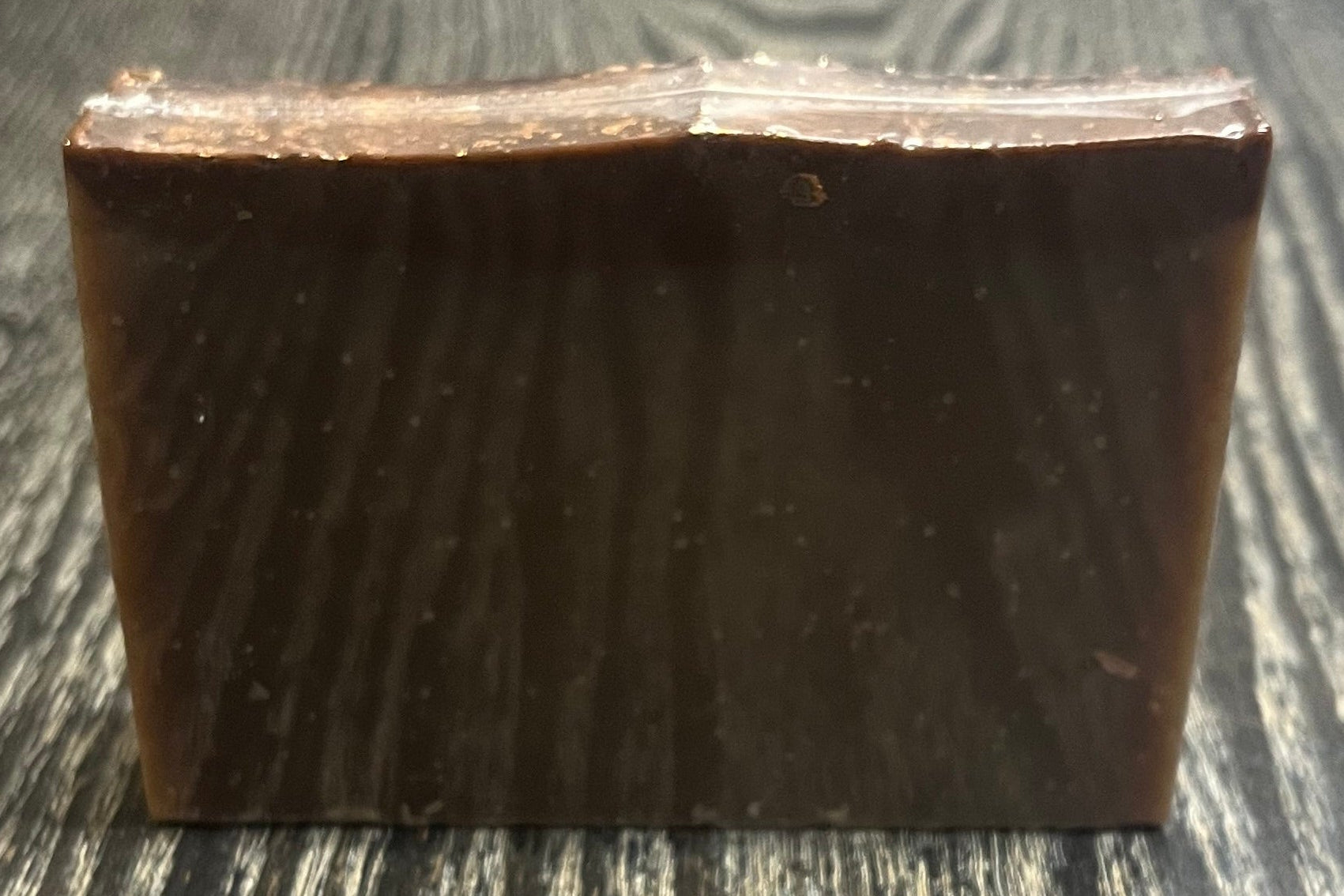 A tan soap bar with a darker brown top layer. 