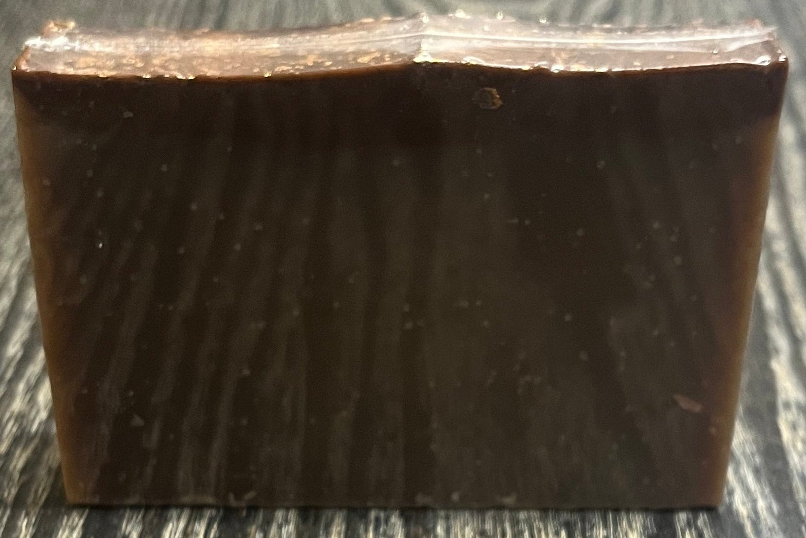 A tan soap bar with a darker brown top layer. 