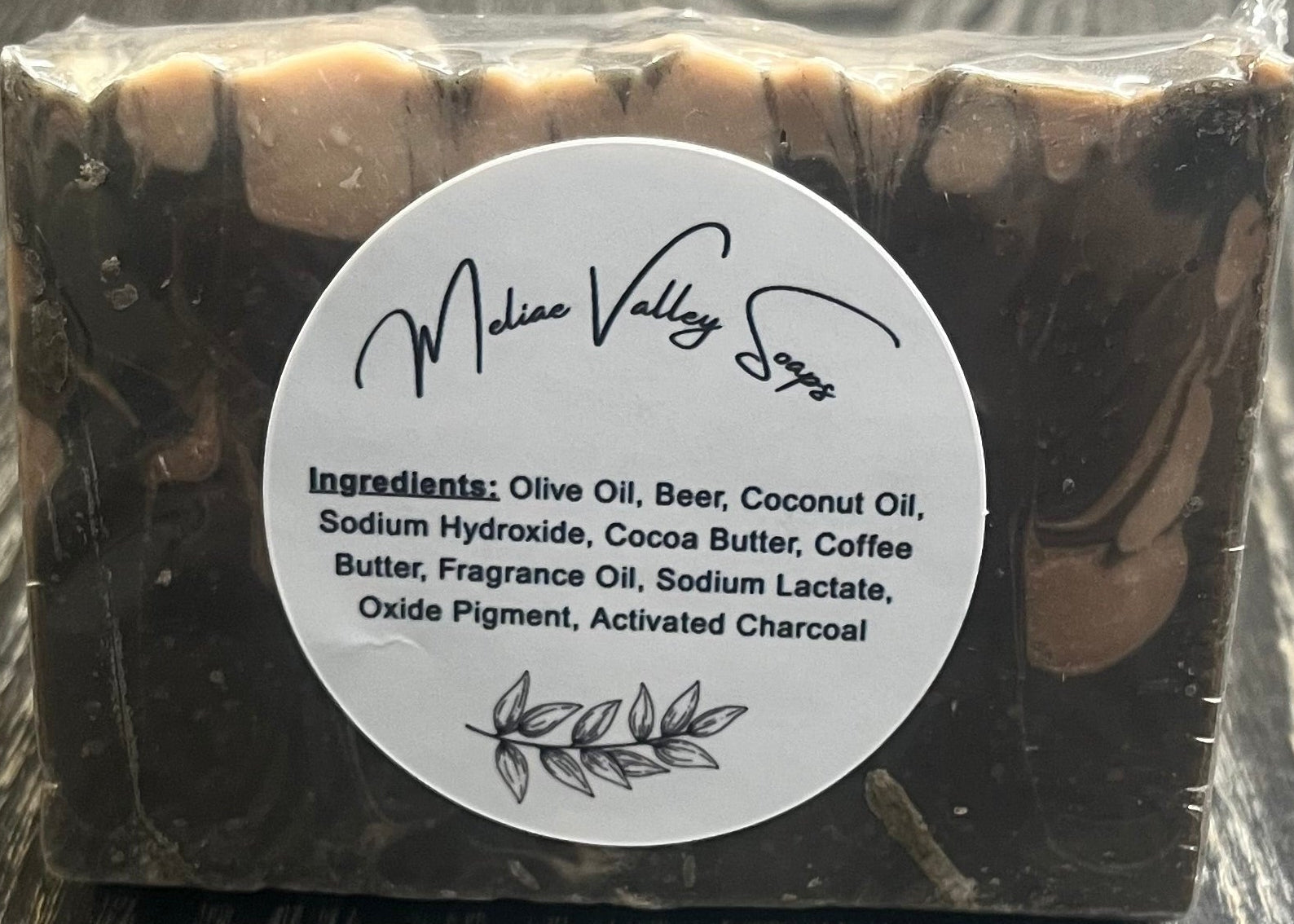 A black and beige marble-patterned soap on a wooden surface. 