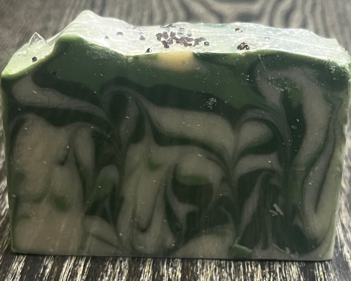 Green and white marbled soap on a wooden surface. 