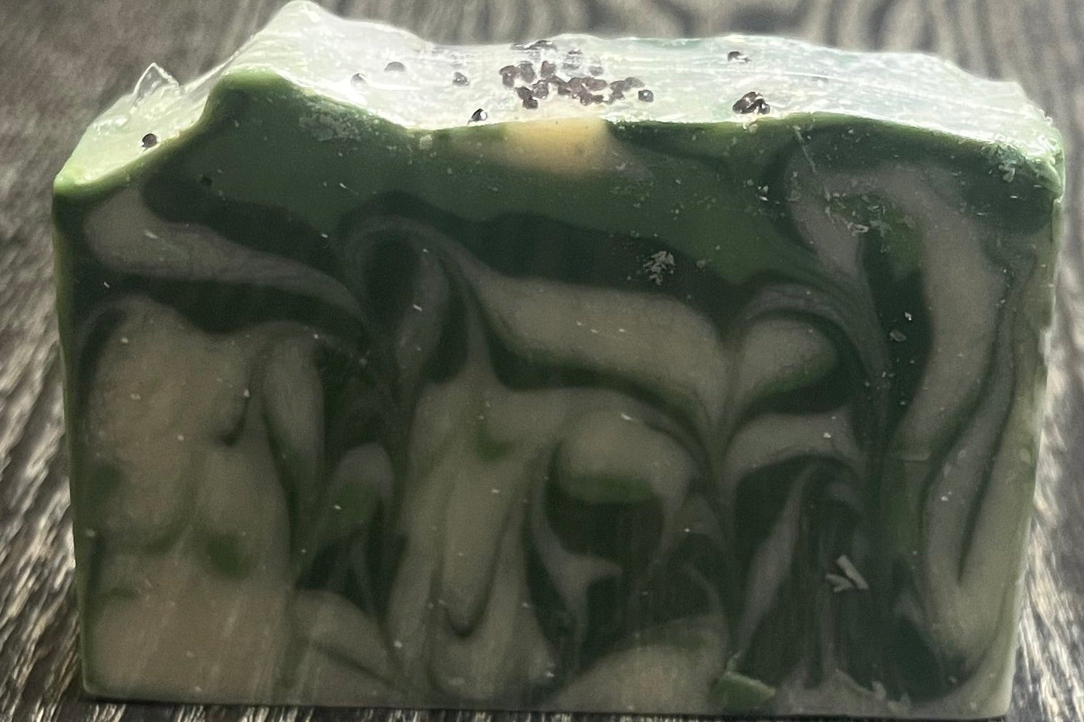 Green and white marbled soap on a wooden surface. 