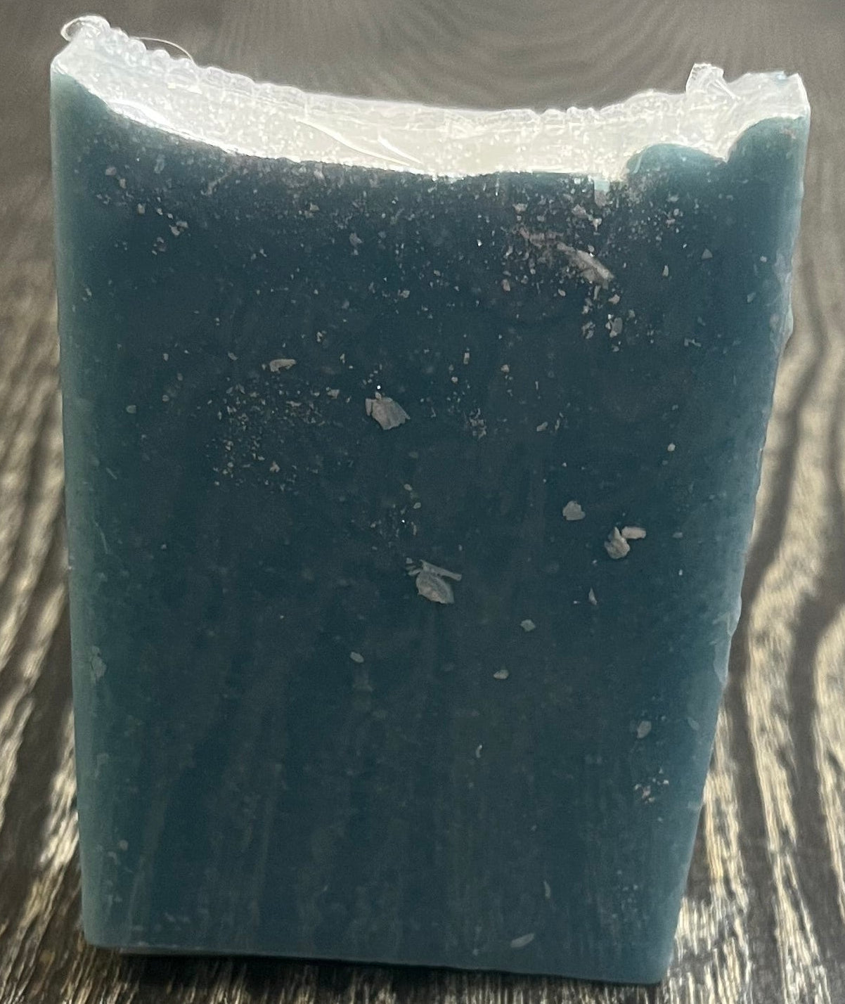 A tall blue bar of soap with a heavy sprinkle of glitter on top. 
