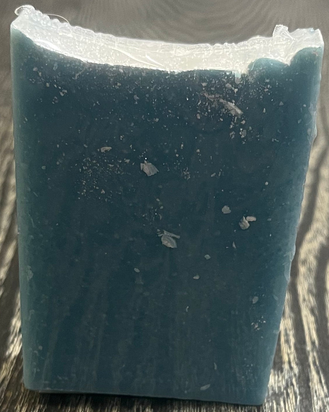 A tall blue bar of soap with a heavy sprinkle of glitter on top. 