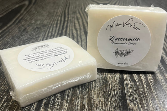 A white bar of soap with a label on a wooden surface.