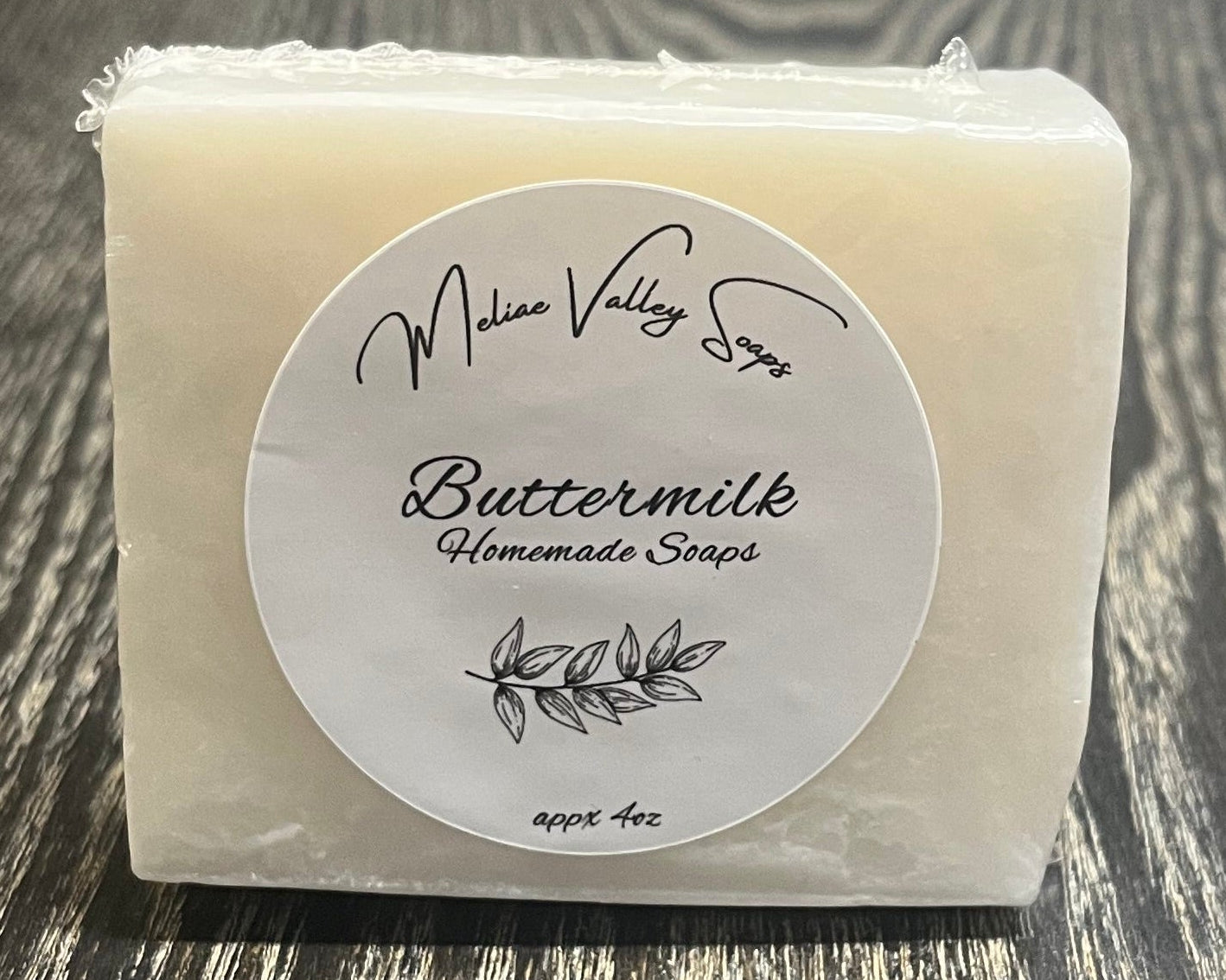 A white bar of soap with a label on a wooden surface.