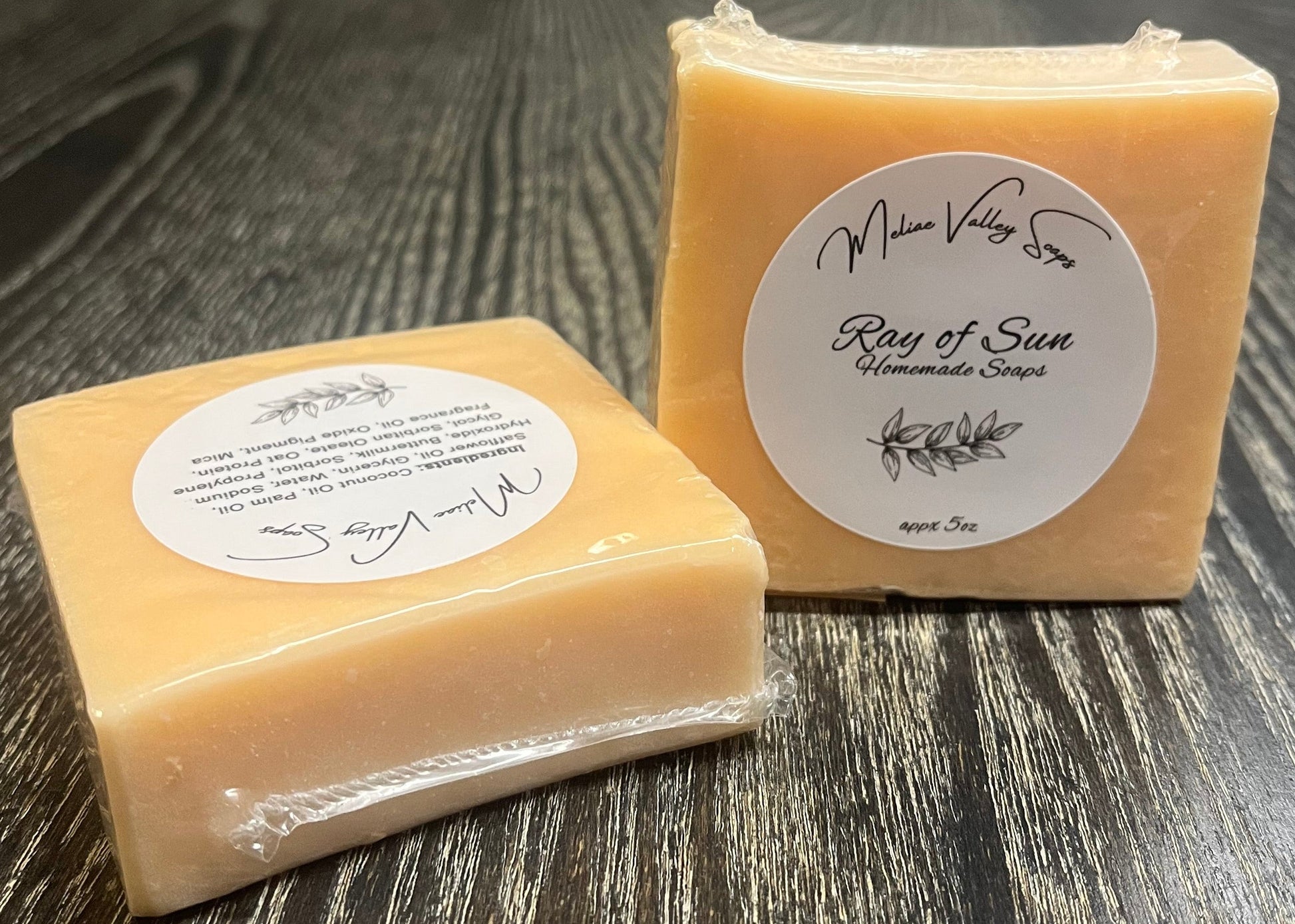 An orange bar of soap with a label on a wooden surface.