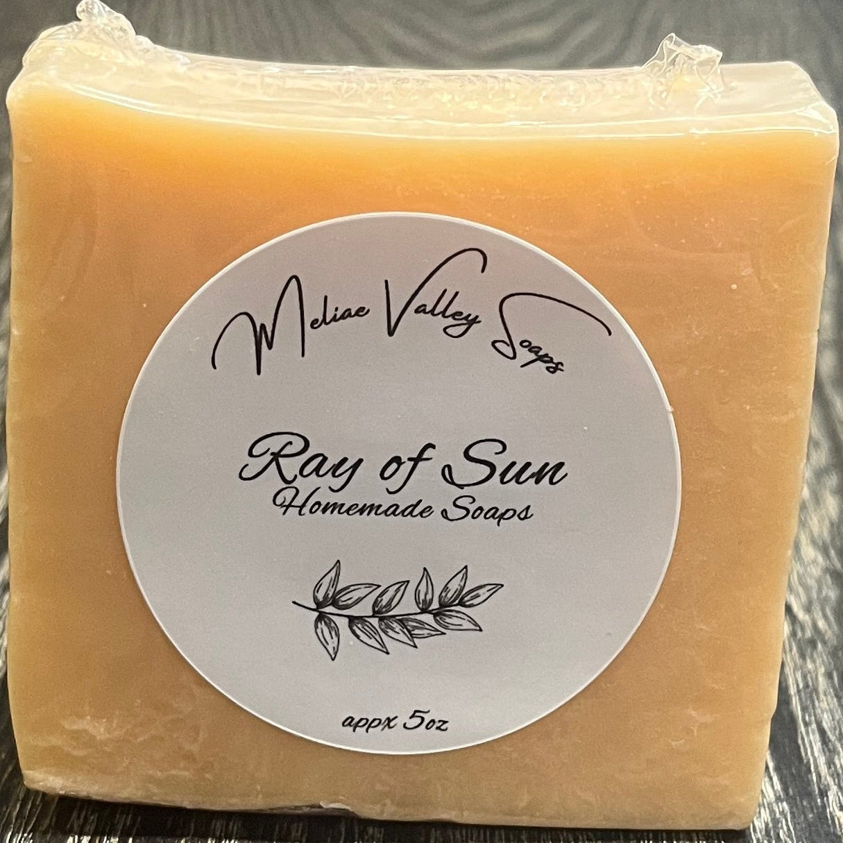 An orange bar of soap with a label on a wooden surface.