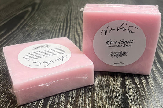 Pink soap bar with a label on a wooden surface.