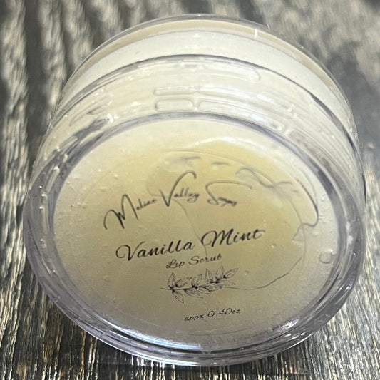 A lip pot filled with sugar dyed white. The lip pot is positioned on its side with its label facing the camera. 