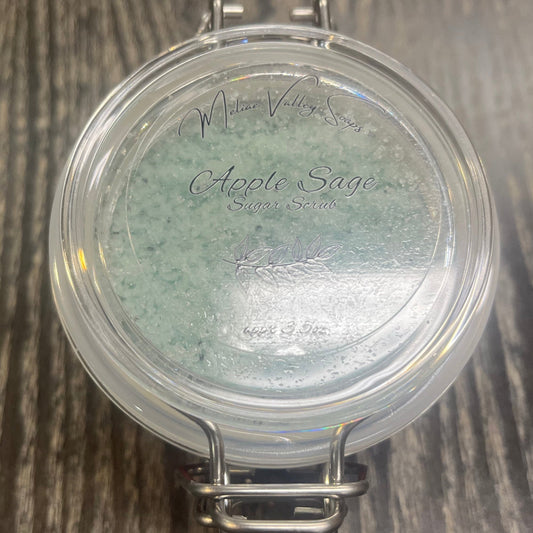 Clear round jar with a sticker on top. You see through the jar to green sugar. 