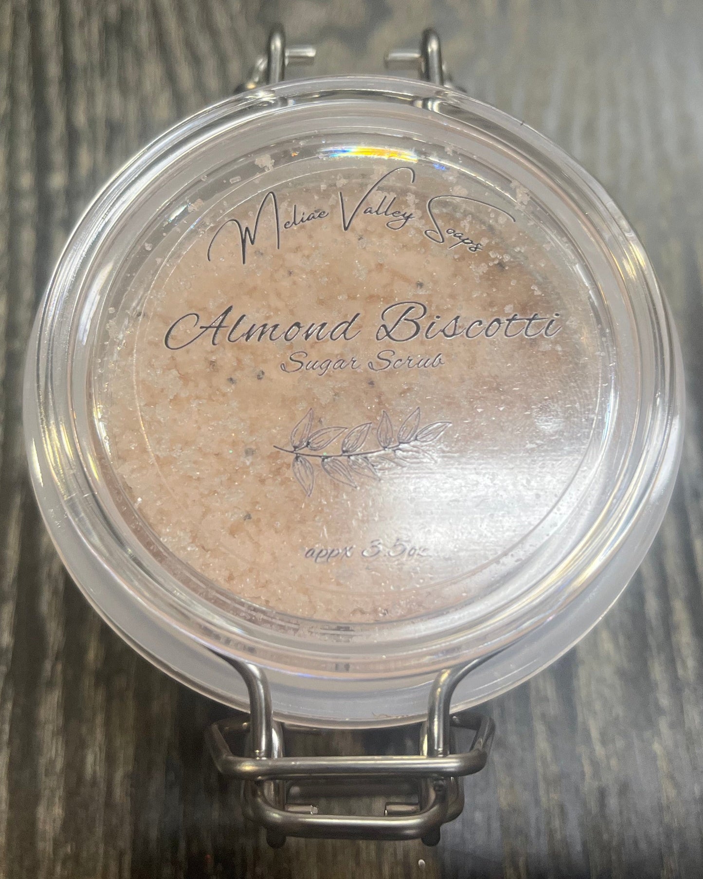 Clear round jar with a sticker on top. You see through to the jar to bronze colored sugar. 