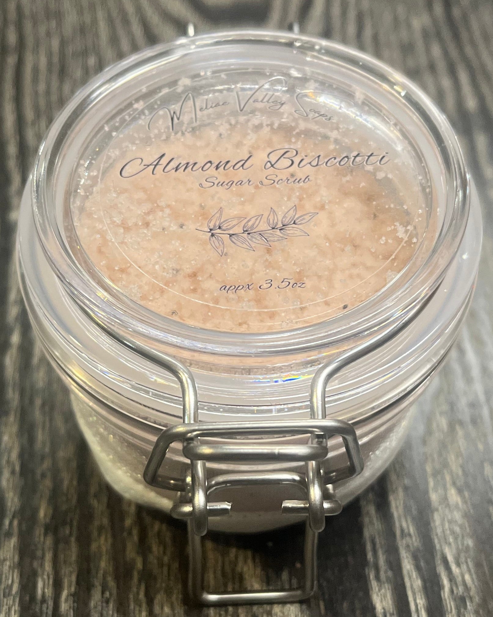 Clear round jar with a sticker on top. You see through the jar to bronze sugar. 