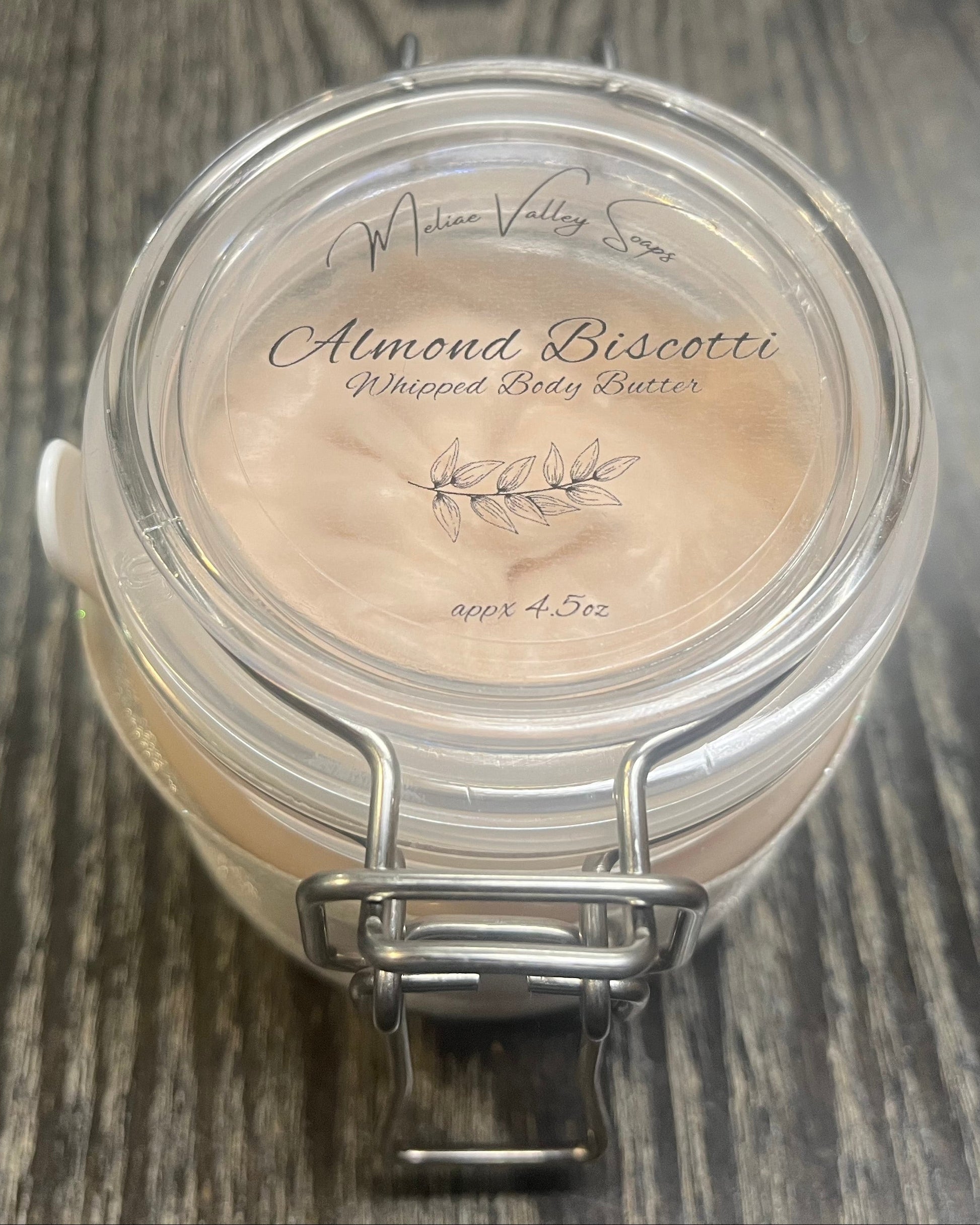 Clear round jar with a sticker on top. You see through to the jar to bronze body butter. 