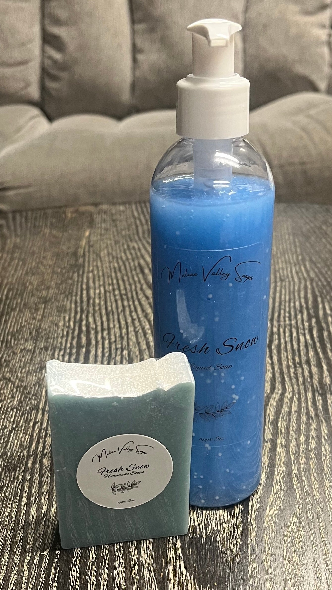 A set of beauty products, including a bottle and a bar on a textured surface.