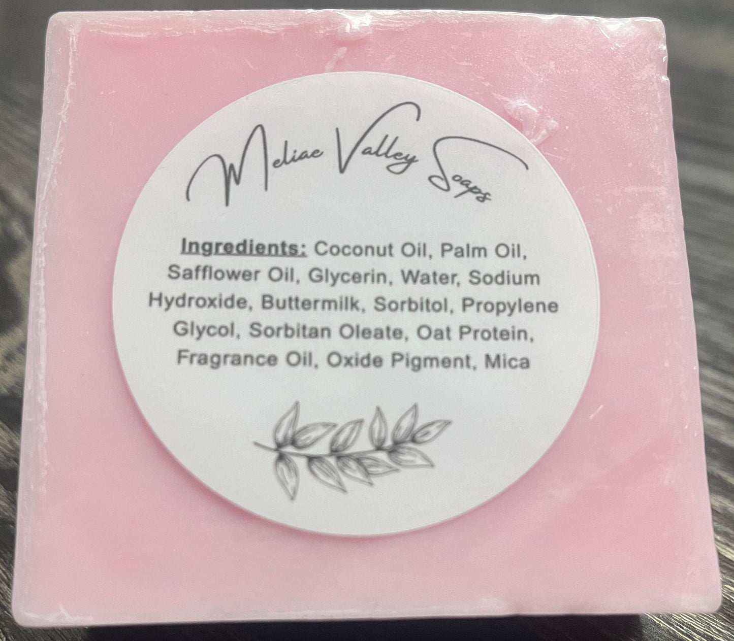 Pink soap bar with a white ingredients label.