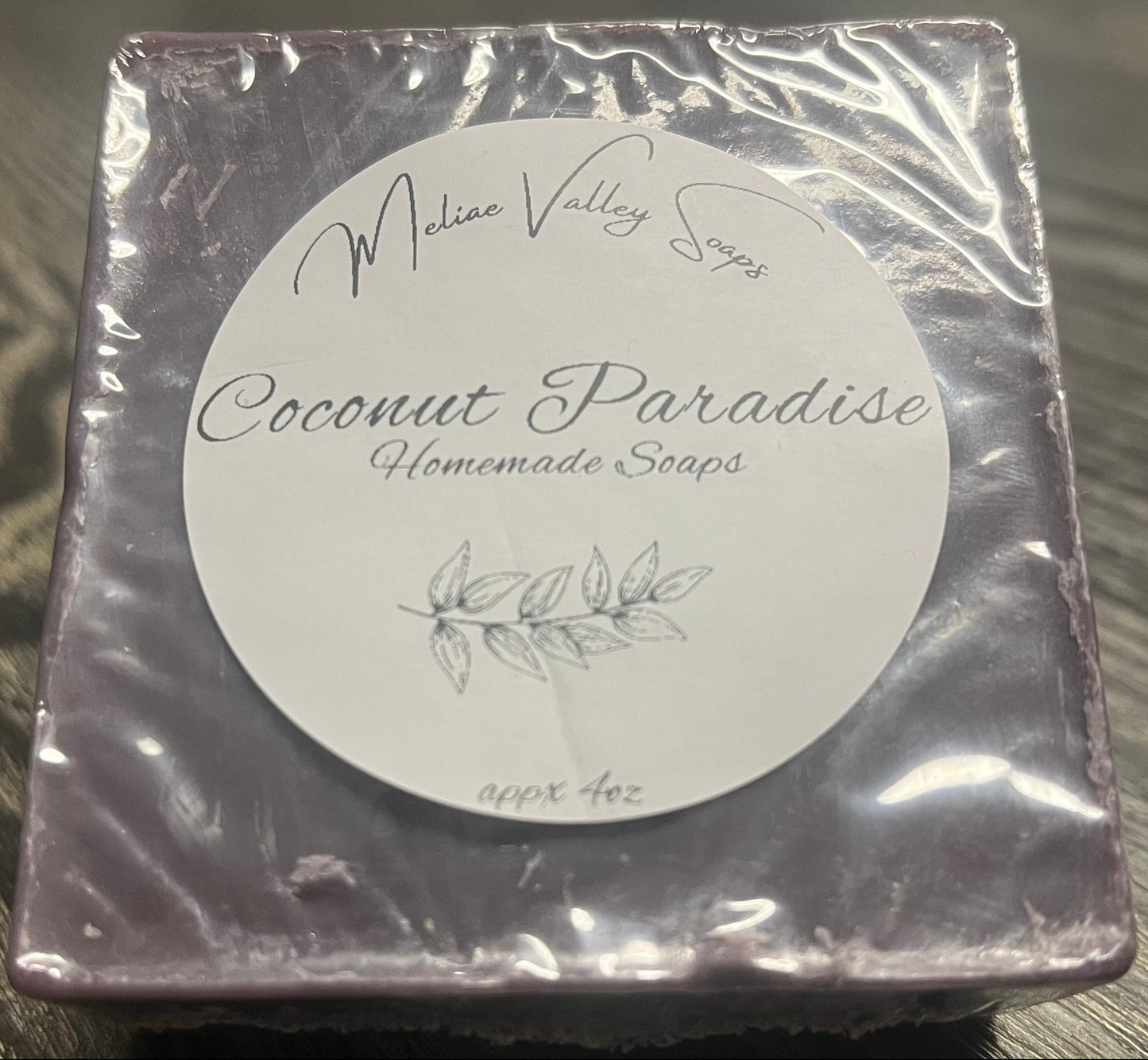 Packaged dark purple soap with a label. 