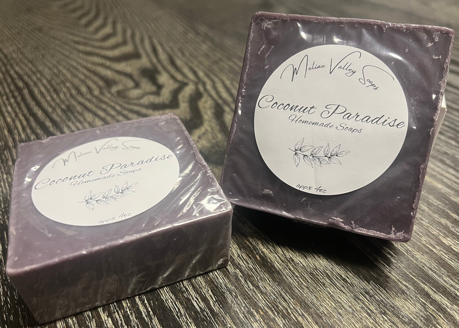 Two bars of dark purple soap labeled 'Coconut Paradise'.