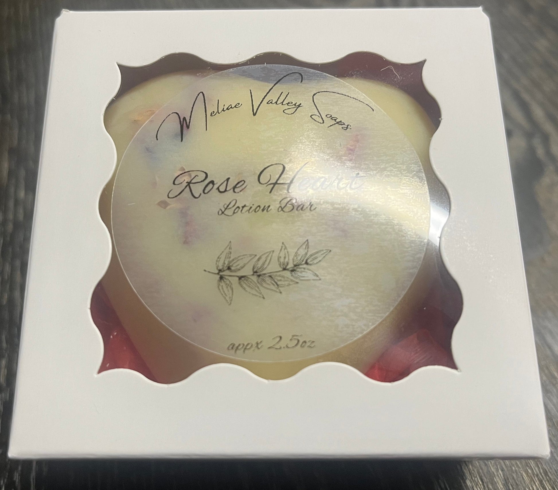 Lotion bar in a decorative box on a wooden surface. 