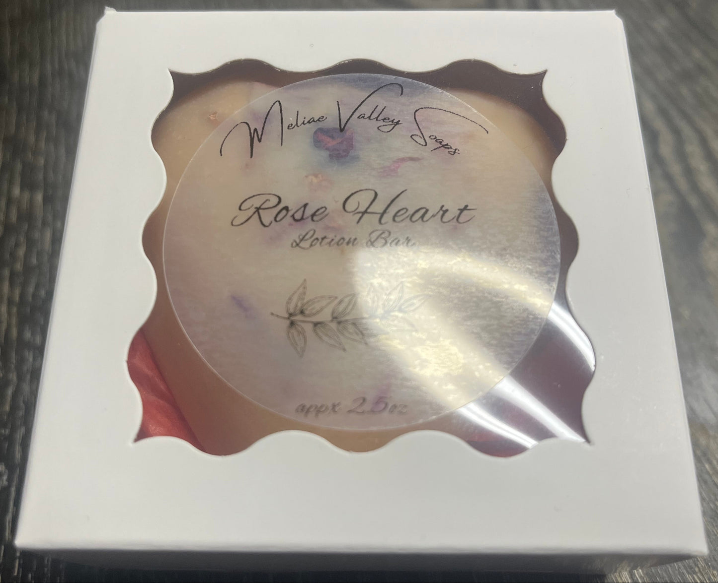 Lotion bar in decorative white box packaging.