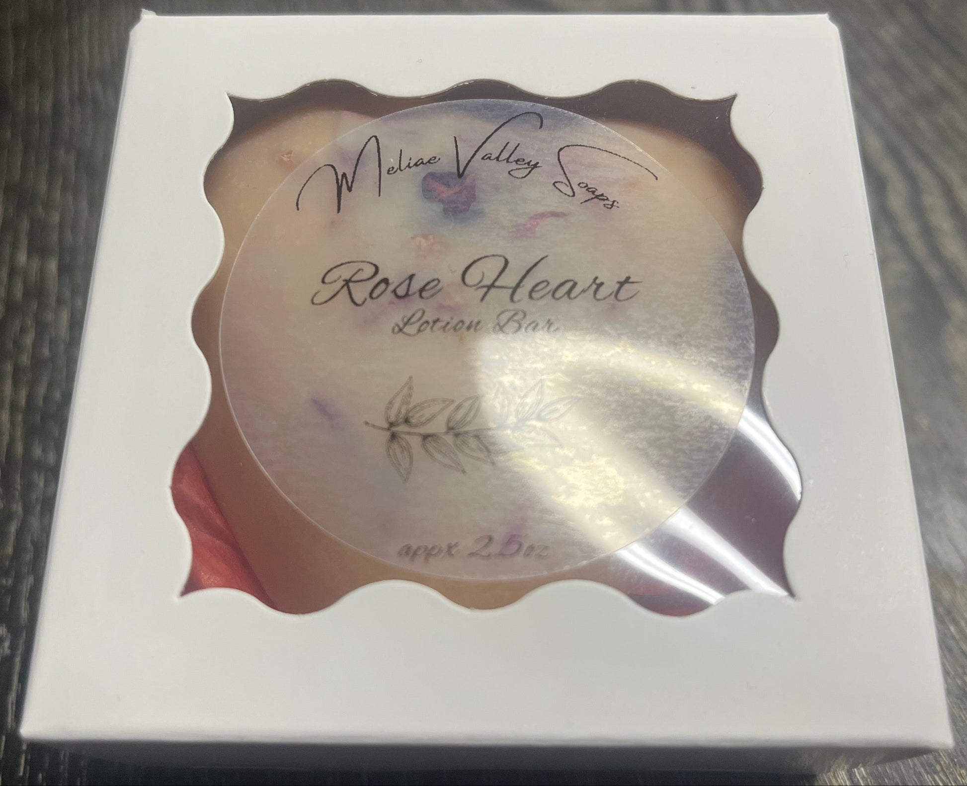 Lotion bar in decorative white box packaging.