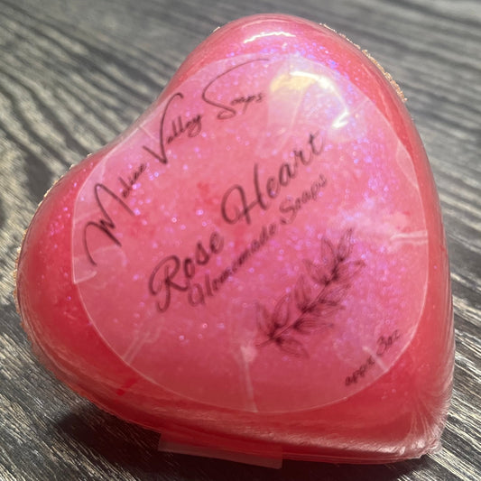 A heart-shaped pink soap bar with a clear label.