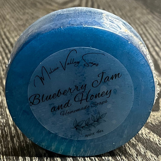A blue bar of soap upright with a clear label on a textured surface. 