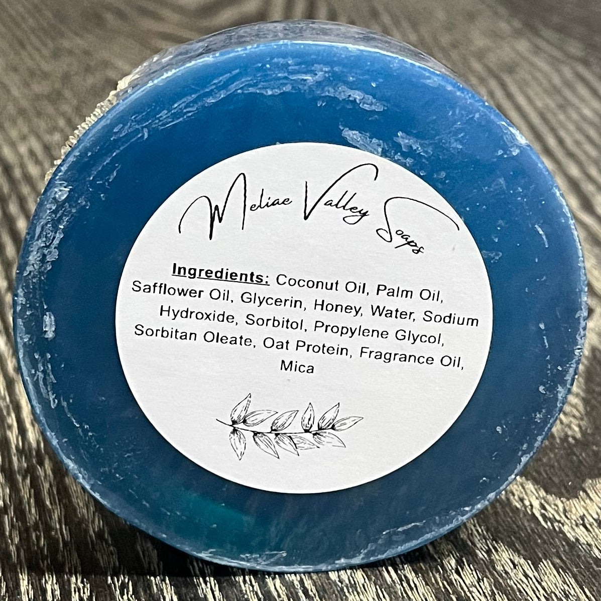 A blue bar of soap upright on its side with a white ingredients label. 