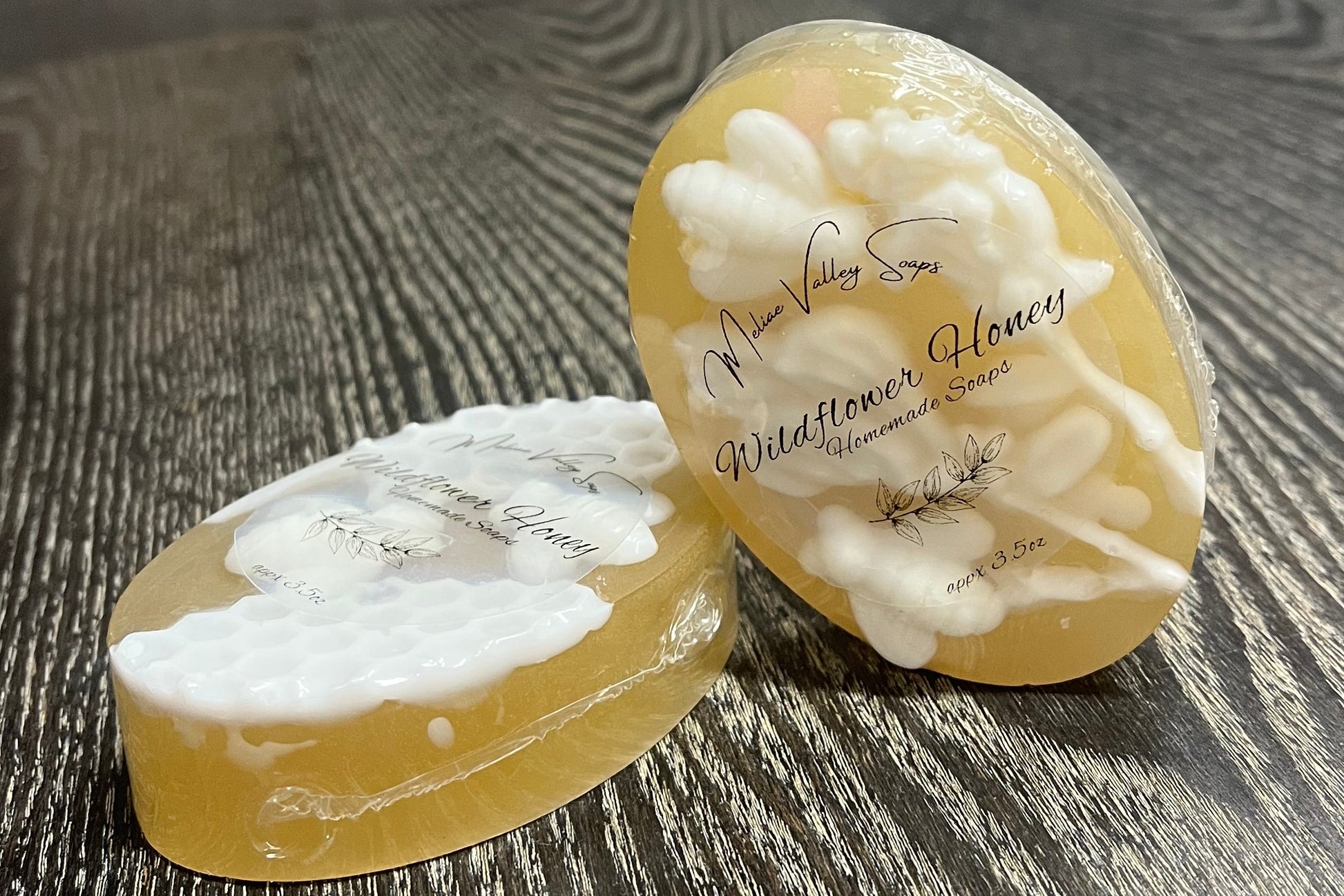 Two bars of amber soap with white details. One is lying down, showing the side of the bar. The other is leaning on the other to show the white details on top of the bars. 