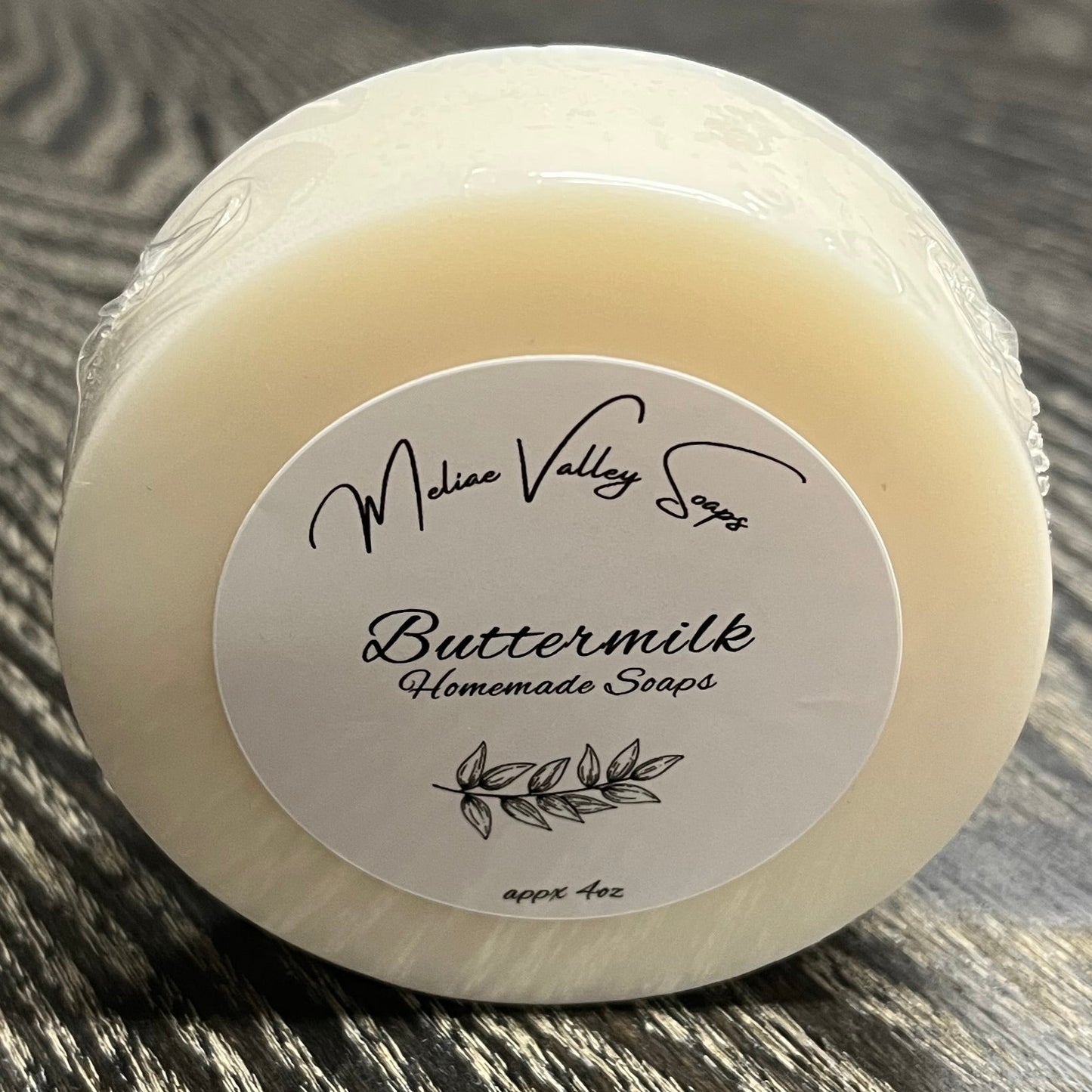 Bar of soap with a label on a wooden surface. 