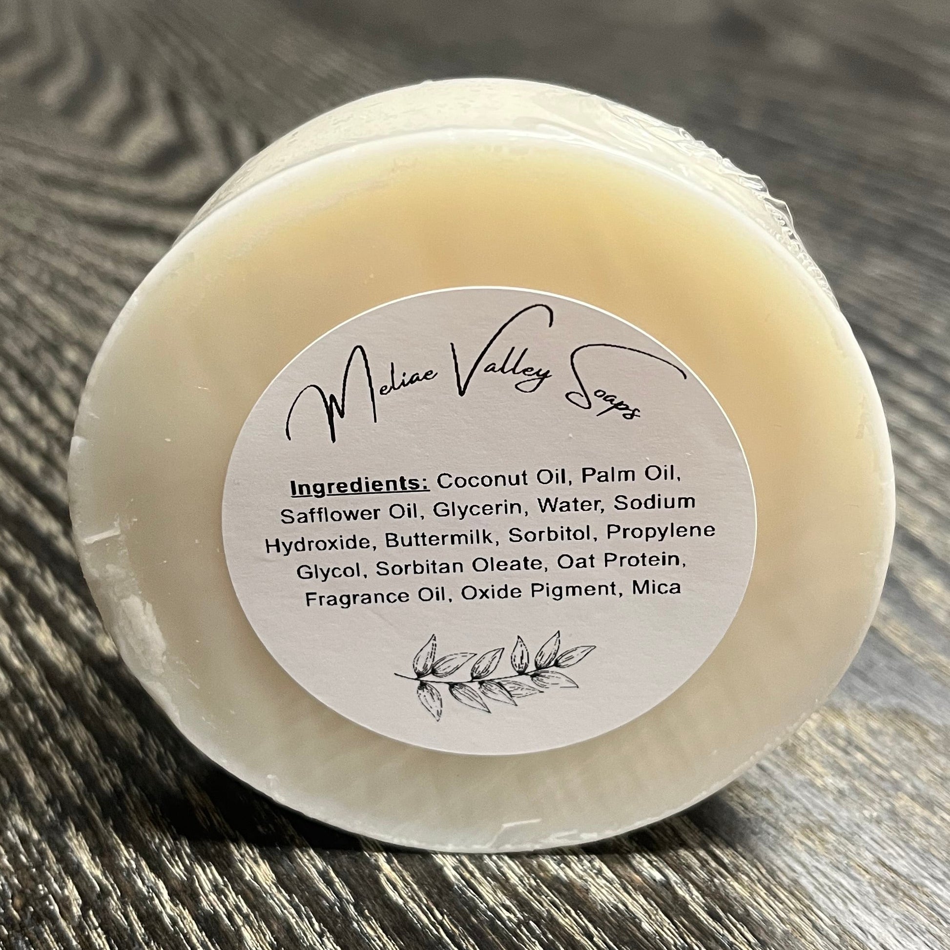 Bar of soap with a label on a wooden surface. 