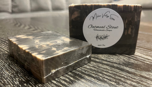 Two bars of soap, one upright with a white label, the other face down, showing the top and back of the bars.