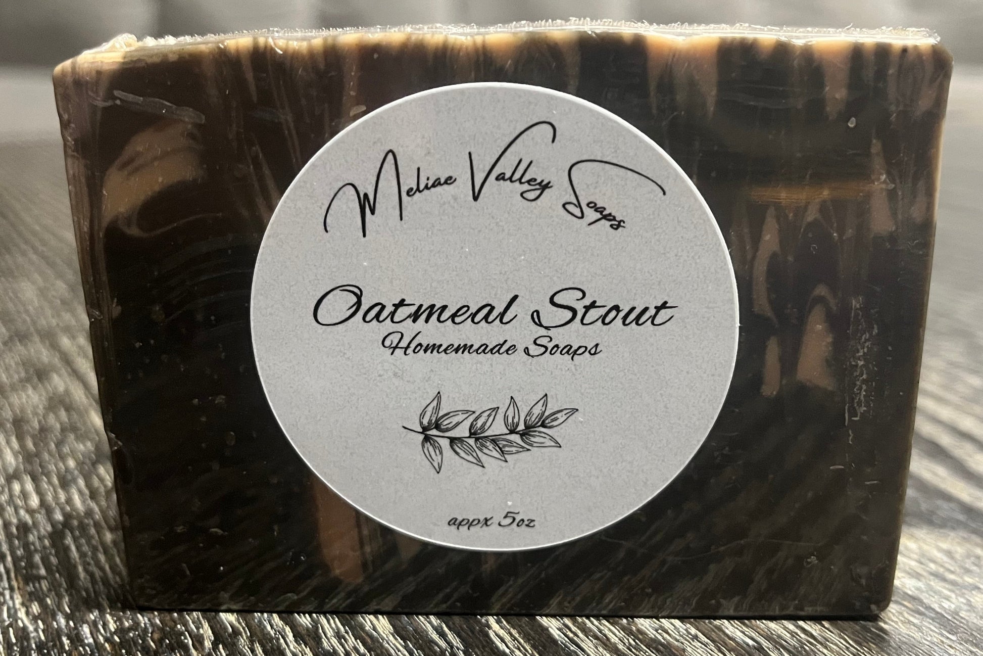 Bar of soap with a label on a wooden surface. 