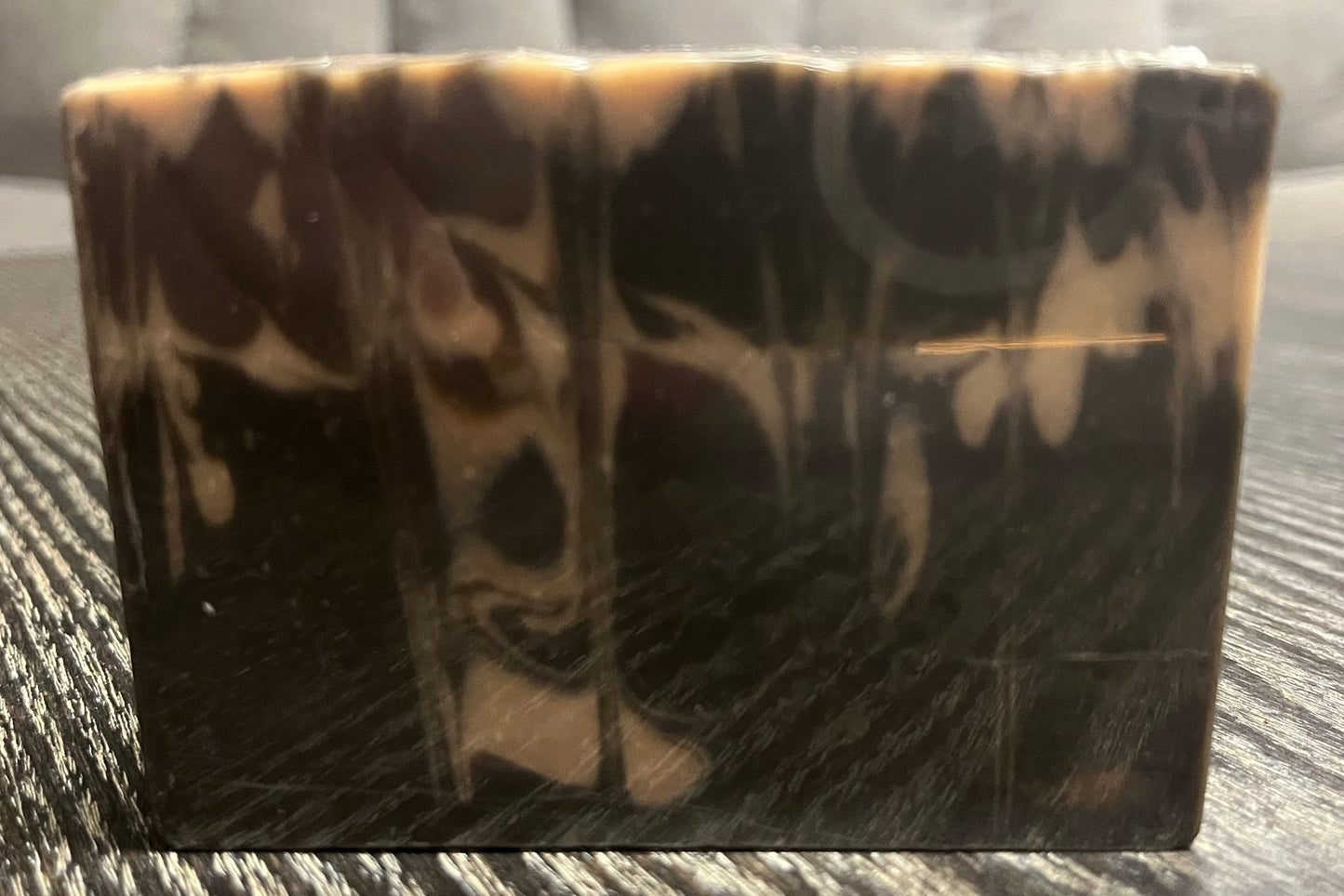 Tortoiseshell-patterned soap bar on a textured surface. 
