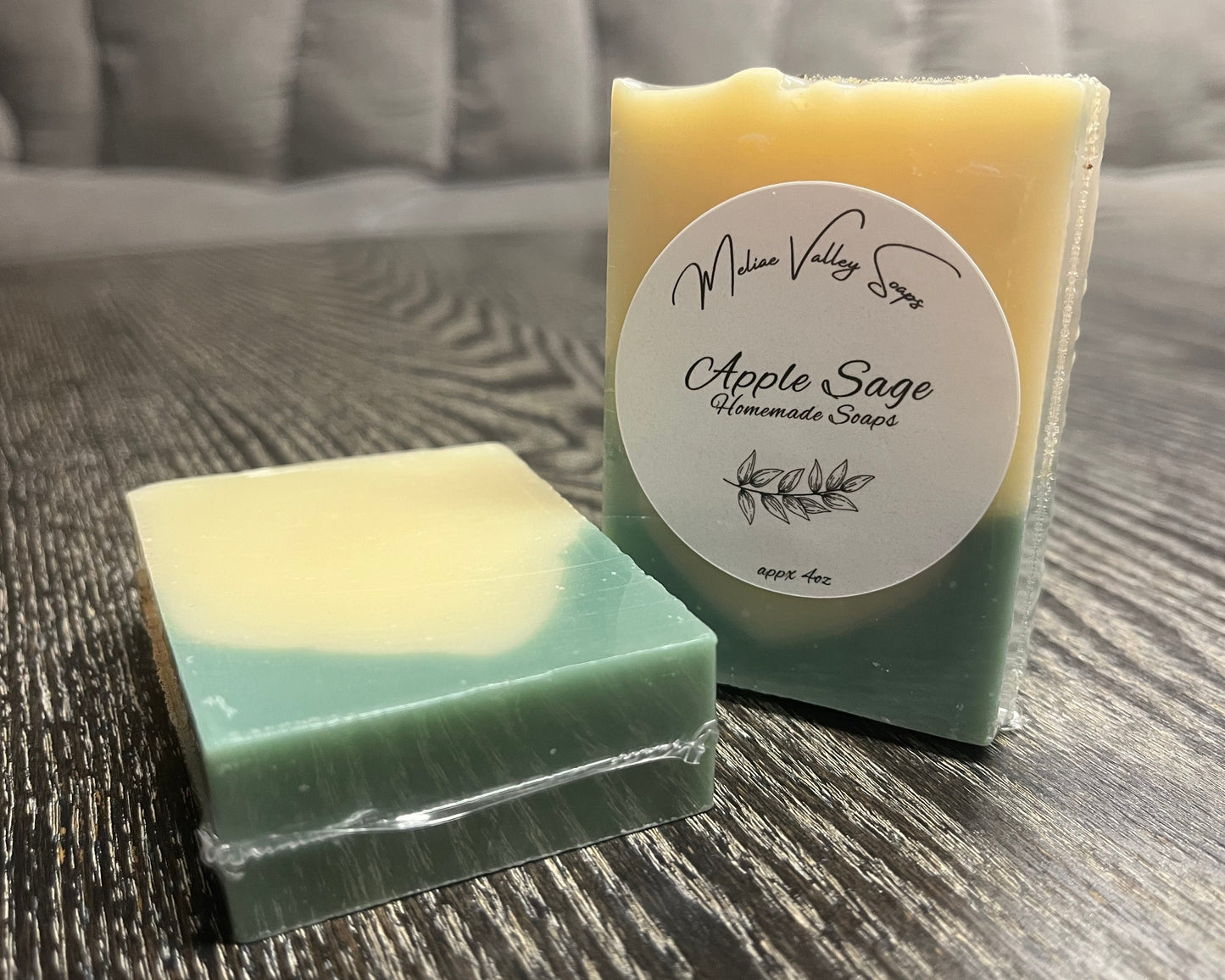 Two bars of soap, one upright with a white label, the other face down, showing the back and bottom of the bars. 