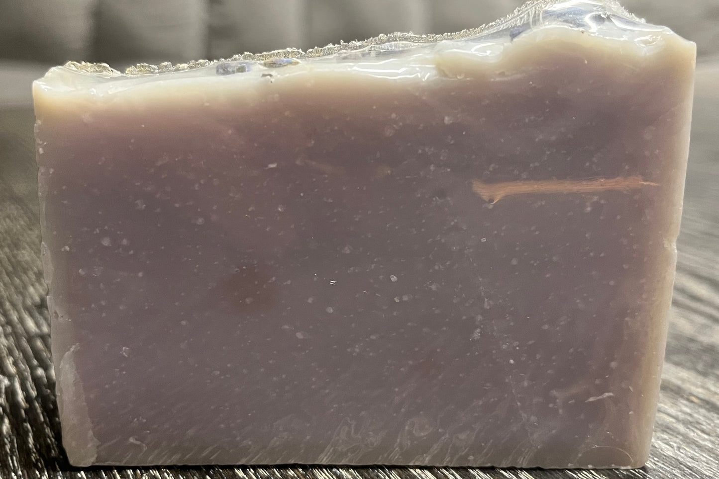 Bar of soap on a wooden surface with a blurred background. 