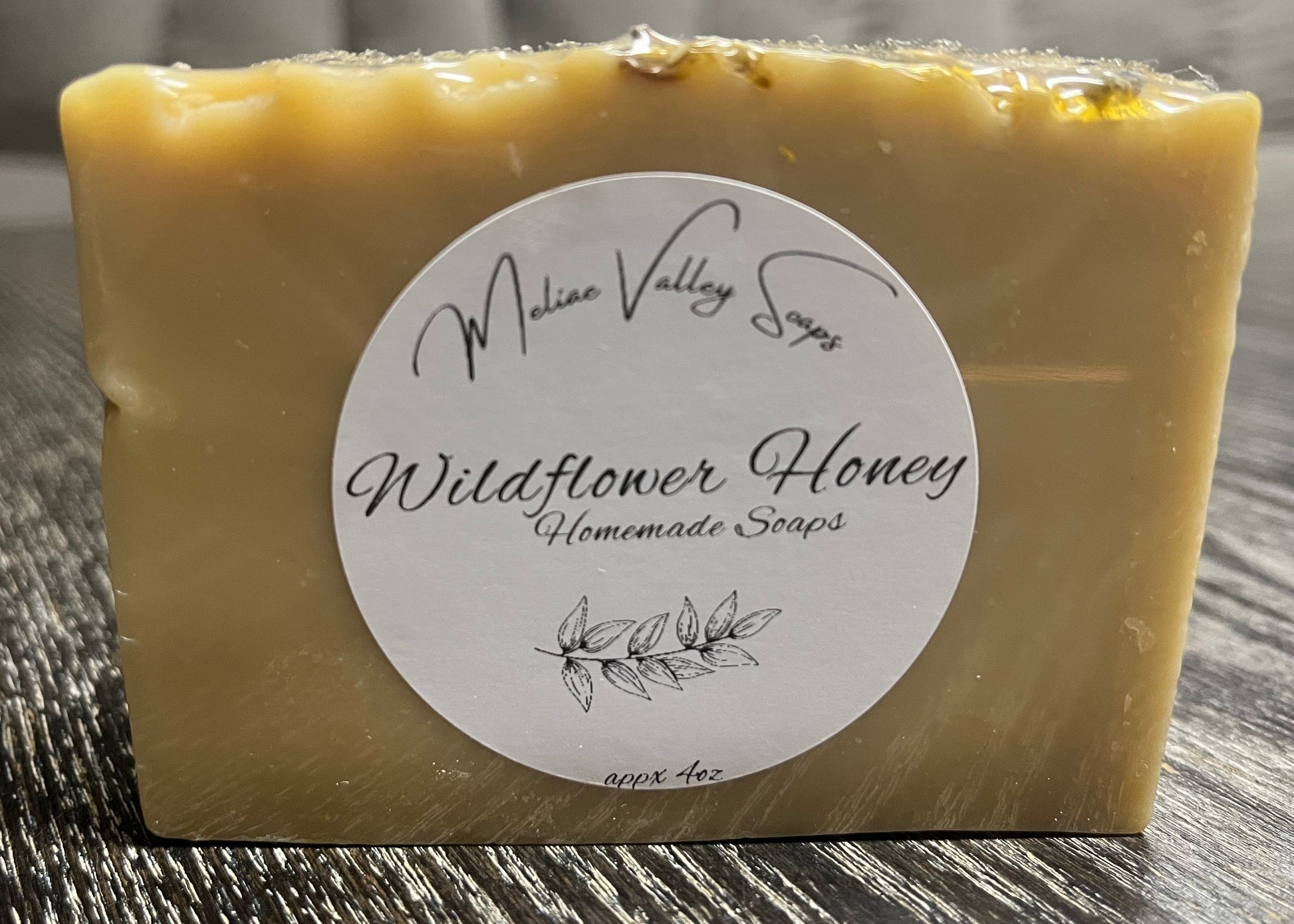 Bar of soap with a label on a wooden surface. 