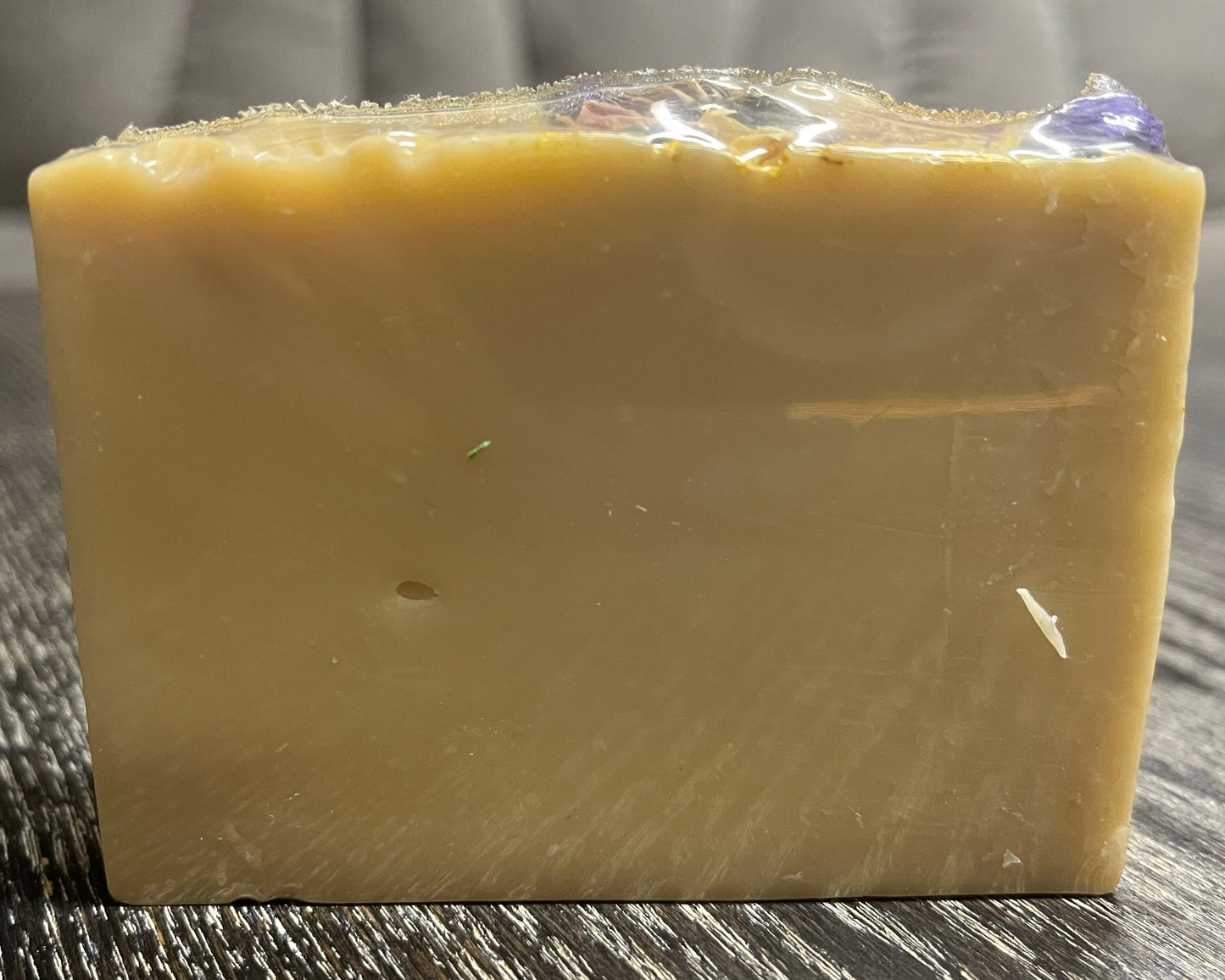 Bar of soap on a wooden surface with a blurred background. 