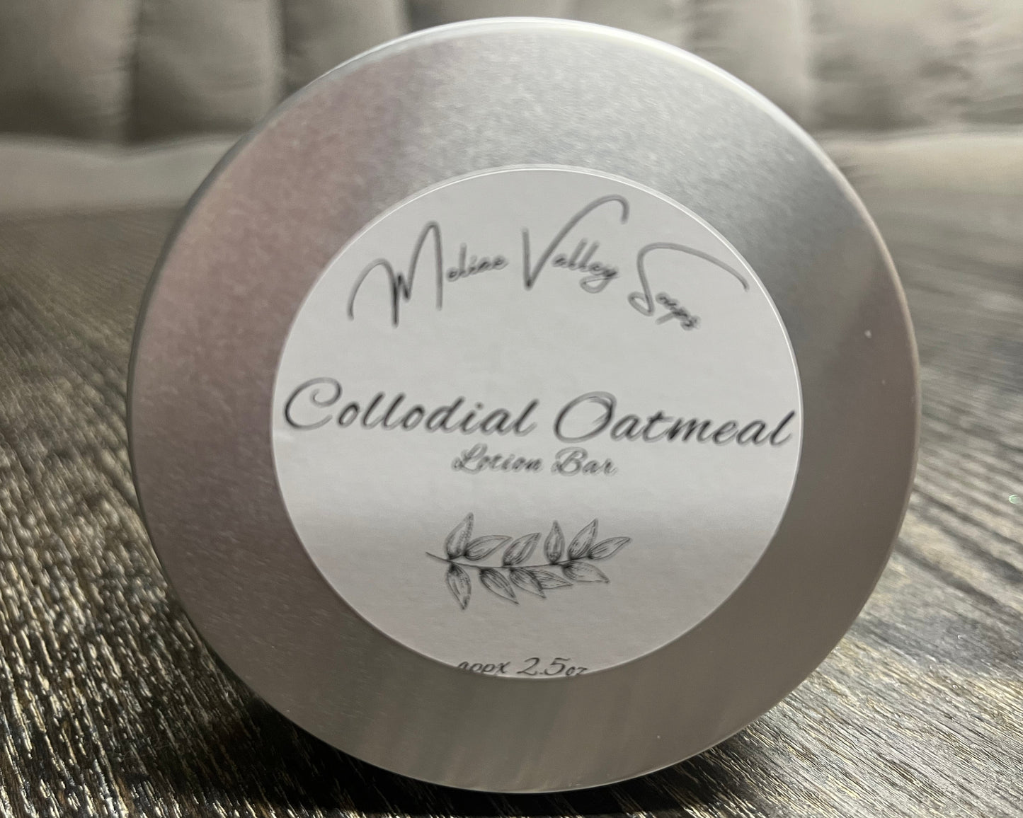 Colloidal Oatmeal lotion bar tin with label on a textured surface
